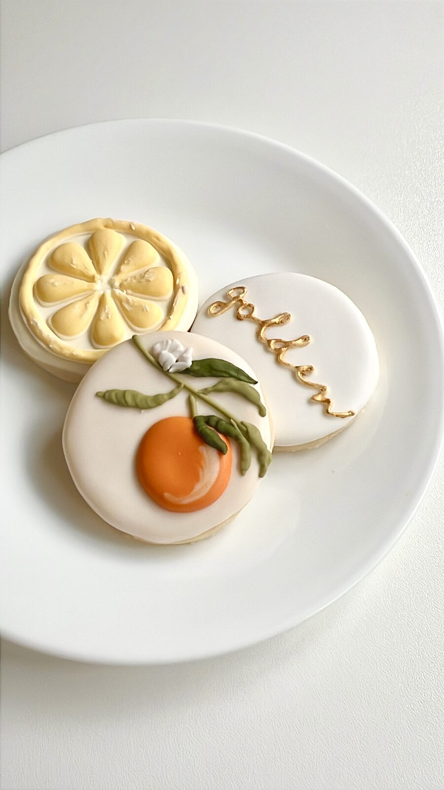 Citrus-themed cookie trio with a lemon slice, orange branch, and gold 'golden' script lettering