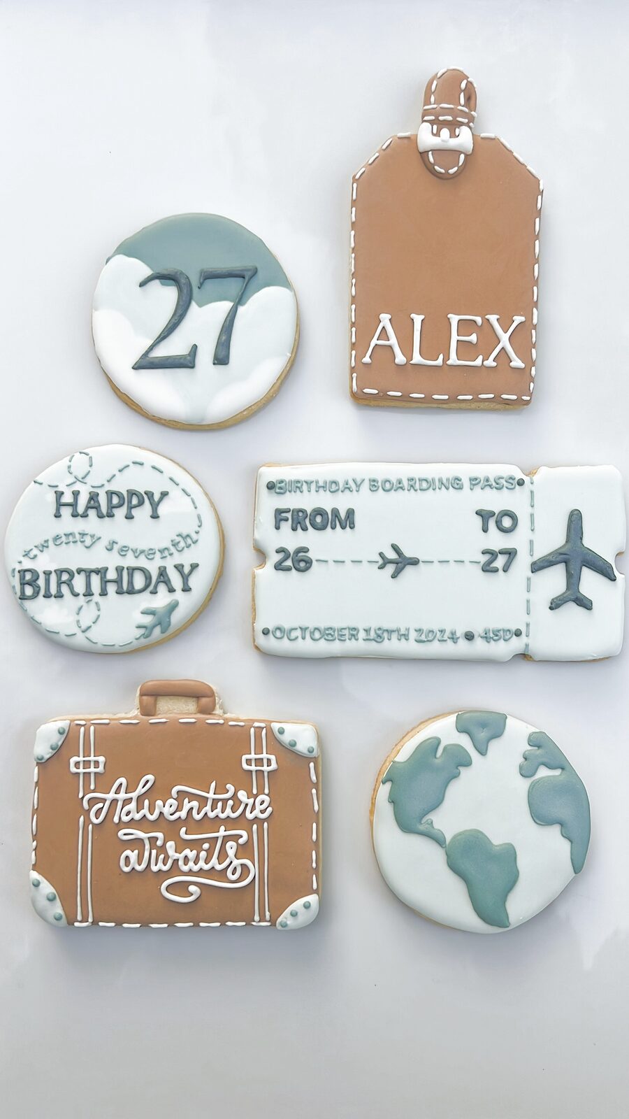 Travel-themed 27th birthday cookie set with a luggage tag, boarding pass, suitcase, and globe design