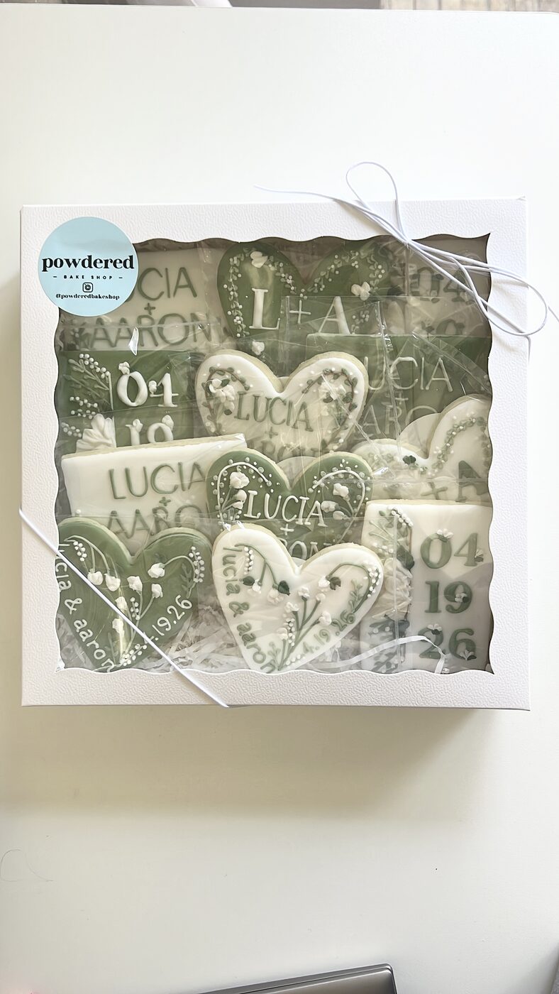 Finished 'Lucia + Aaron' wedding cookie gift box with sage green hearts and floral details, ready for pickup